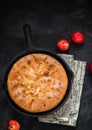 Homemade apple pie in vintage iron pan on dark background.