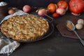Homemade apple pie on vintage tray, apples, pumpkins, dry leaves and pie ingredients