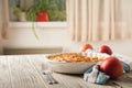 Homemade apple pie on a white wooden background near the window close-up and copy space. Charlotte in the morning on the table