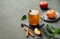Homemade apple punch with fresh apples, cinnamon and spices in cup on a green background with fresh fruits and branch. A hot Royalty Free Stock Photo