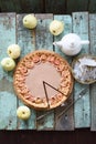 Homemade apple rose open pie with cream filling served with organic apples and tea on blue coarse wood background Royalty Free Stock Photo