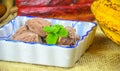 Homemade artisanal chocolate ice cream on a ceramic bowl with spoon and cacao pods on the background