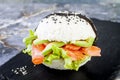 Homemade asian style gluten free sushi salmon burger. Sushi-food hybrids trend. Bright blue background with copy space.