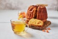 Homemade autumn carrot or pumpkin bundt cake with candied fruits, cup of tea and golden decorative pumpkins