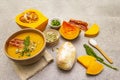 Homemade autumn hot pumpkin cream soup with smocked bacon and seeds. Raw pumpkin, bun, fresh chives, dill, salt in spoon, vintage Royalty Free Stock Photo