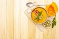Homemade autumn hot pumpkin cream soup with smocked bacon and seeds. Raw pumpkin, fresh chives, dill, salt in spoon, vintage linen Royalty Free Stock Photo