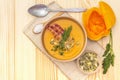 Homemade autumn hot pumpkin cream soup with smocked bacon and seeds. Raw pumpkin, fresh chives, dill, salt in spoon, vintage linen Royalty Free Stock Photo