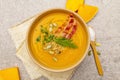 Homemade autumn hot pumpkin cream soup with smocked bacon and seeds. Raw pumpkin, fresh chives, dill, salt in spoon, vintage linen Royalty Free Stock Photo