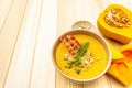 Homemade autumn hot pumpkin cream soup with smocked bacon and seeds. Raw pumpkin, fresh chives, dill, salt in spoon on wooden Royalty Free Stock Photo