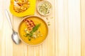 Homemade autumn hot pumpkin cream soup with smocked bacon and seeds. Raw pumpkin, fresh chives, dill, salt in spoon on wooden Royalty Free Stock Photo