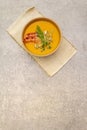 Homemade autumn hot pumpkin cream soup with smocked bacon and seeds. Raw pumpkin, fresh chives, dill, vintage linen cloth on stone Royalty Free Stock Photo