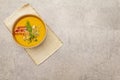 Homemade autumn hot pumpkin cream soup with smocked bacon and seeds. Raw pumpkin, fresh chives, dill, vintage linen cloth on stone Royalty Free Stock Photo