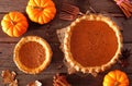 Homemade autumn pumpkin pies, overhead table scene on rustic wood Royalty Free Stock Photo