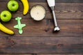 Homemade baby food. Cook puree with apple and banana with immersion blender. Dark wooden background with toy top view Royalty Free Stock Photo