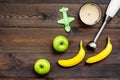 Homemade baby food. Cook puree with apple and banana with immersion blender. Dark wooden background with toy top view Royalty Free Stock Photo