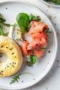 Homemade bagel sandwich with smoked salmon, cream cheese, capers and spinach for healthy breakfast close up top view Royalty Free Stock Photo