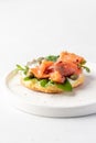 Homemade bagel sandwich with smoked salmon, cream cheese, capers and spinach for healthy breakfast isolated on white Royalty Free Stock Photo
