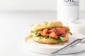 Homemade bagel sandwich with smoked salmon, cream cheese, capers and spinach for healthy breakfast on white kitchen Royalty Free Stock Photo