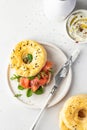 Homemade bagel sandwich with smoked salmon, cream cheese, capers and spinach for healthy breakfast on white kitchen Royalty Free Stock Photo