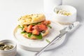 Homemade bagel sandwich with smoked salmon, cream cheese, capers and spinach for healthy breakfast on white kitchen Royalty Free Stock Photo