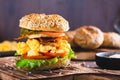 Homemade bagel with scramble egg, bacon, cheese, tomato and lettuce on a board Royalty Free Stock Photo