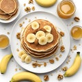 Homemade bake banana pancakes with topping fresh banana slices, walnuts and honey on whit plate, Top view