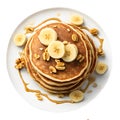 Homemade bake banana pancakes with topping fresh banana slices, walnuts and honey on whit plate, Top view