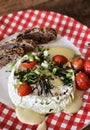 Homemade baked camembert cheese with green onions, rosemary, cherry tomatoes, chives and fresh bread Royalty Free Stock Photo