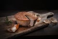 Homemade, baked meat pate. Rustic composition with cut pate on a wooden chopping board, on a black background.