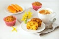 Homemade baked pastries. Healthy pumpkin muffins with traditional fall spices, pieces of pumpkin on saucer. White cup with tea on Royalty Free Stock Photo