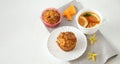 Homemade baked pastries. Healthy pumpkin muffins with traditional fall spices, pieces of pumpkin on saucer. White cup with tea on Royalty Free Stock Photo