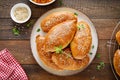 Homemade baked pies or patties stuffed with cabbage on wooden background. Top view Royalty Free Stock Photo