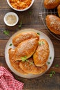 Homemade baked pies or patties stuffed with cabbage on wooden background. Top view Royalty Free Stock Photo