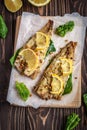 Baked pollock fillet with lemon and spinach on a wooden background