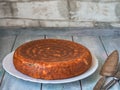 Homemade baking. Closed fish cake on a white plate standing on a blue wooden tray