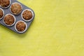 Homemade baking concept - fresh baked muffins on cooling rack, minimal picture, bright yellow background, background, top view,