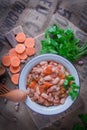 Homemade bean soup, carrots, onions and parsley. Vertical top view