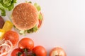 Homemade burger with ingredients on white table top Royalty Free Stock Photo