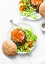 Homemade beef burger with spicy marinated carrots and green salad - delicious snack, brunch, tapas on a light background, top view