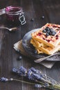 Homemade belgian waffles with blueberries and jam on the dark wooden table