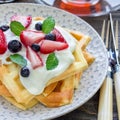 Homemade belgian waffles with yogurt, strawberry and blueberry, breakfast time, square Royalty Free Stock Photo