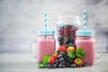 Homemade berry smoothie in jars and blender