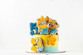 Homemade birthday yellow cake decorated with ginerbread cookies in the shape of minions. Characters of the animated movie ``