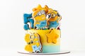 Homemade birthday yellow cake decorated with ginerbread cookies in the shape of minions. Characters of the animated movie ``