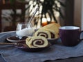 Homemade biscuit sponge roll with sweet plum jam and tea against a dark background. Natural homemade dessert, side view. Royalty Free Stock Photo