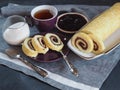 Homemade biscuit sponge roll with sweet plum jam and tea against a dark background. Natural homemade dessert, side view Royalty Free Stock Photo