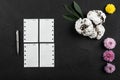 Homemade biscuits, white sheets for notes, a silver pen and flowers on stone black table Royalty Free Stock Photo