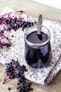 Homemade black elderberry syrup in glass bowl and jar Royalty Free Stock Photo