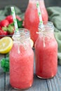 Homemade blended lemonade with fresh strawberry, lemon, ice and mint in bottle, vertical