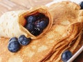 Homemade blinis or crepes with blueberries and jam